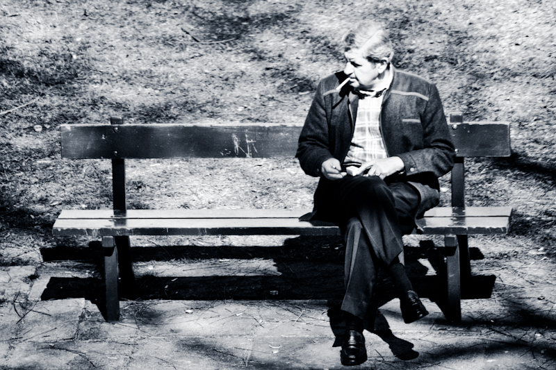 a man on a park bench smoking